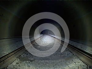 Dark tunnel railway with flash lamp light