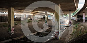 Dark underbridge with columns and graffiti