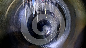 Dark underground sewer round concrete tunnel. Industrial wastewater and urban sewage flowing throw sewer pipe