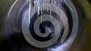 Dark underground sewer round concrete tunnel. Industrial wastewater and urban sewage flowing throw sewer pipe