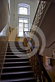 Dark vintage staircase interior in old building, stair with forged railing