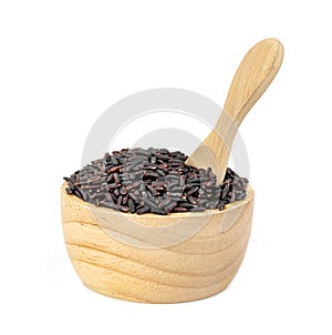 Dark violet rice berry with wooden bowl and spoon isolated on white background