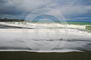 Dark volcanic Whirinaki Beach, Hawke`s Bay region, New Zealand