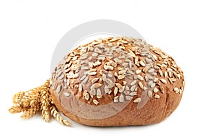 Dark whole grain bread with seeds and spikelet of wheat isolated on white background