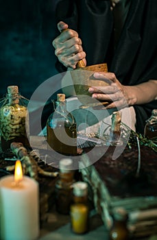 Dark Witch at work: black magic woman makes the witchery by mixing herbs, casting the spells, running magic rituals