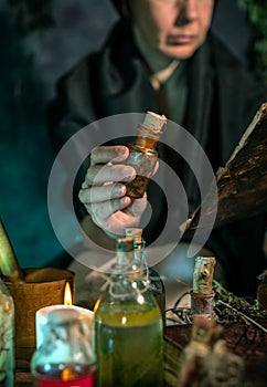 Dark Witch at work: black magic woman makes the witchery by mixing herbs, casting the spells, running magic rituals