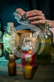 Dark Witch at work: black magic woman makes the witchery by mixing herbs, casting the spells, running magic rituals
