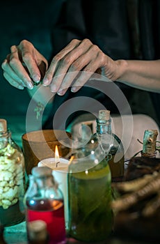 Dark Witch at work: black magic woman makes the witchery by mixing herbs, casting the spells, running magic rituals