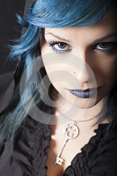 Dark woman with blue hair and lipstick. Key pendant. Dark girl