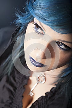 Dark woman with blue hair and lipstick. Key pendant. Dark girl