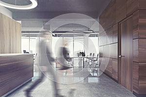 Dark wood reception in open space office, people