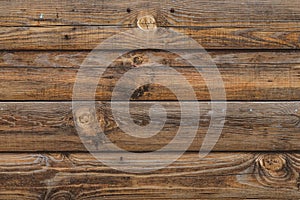 Dark wooden fence. Shabby table, dirty pine lumber. Old wood boards. Pattern, surface of logs. Backgrounds of cracked planks, bar.