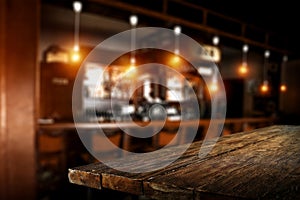 Dark wooden table top with free space and blurred background of bar