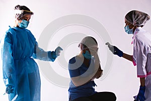 Darkened photo. Poor health of the health worker. Woman doctor holding her head. The nurse measures the temperature with