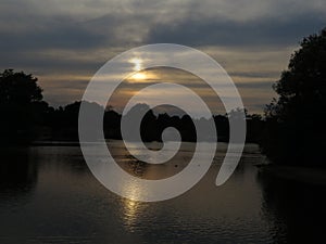 Darkened sunset over a lake with atmophere