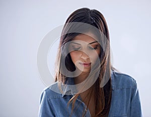 Darkly demure. Studio shot of a gorgeous brunette model with her eyes closed.