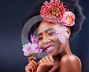 Darling, be daring. Studio shot of a beautiful young woman posing with flowers in her hair.