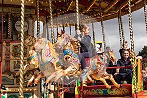 People riding on carousel horse on fairground ride