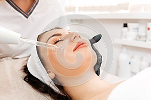 Darsonval cosmetology apparatus. Professional skin care in the salon. Woman on the darsonval therapy in beauty salon