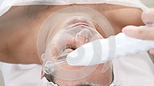 Darsonvalization. Man having darsonval therapy. Facial skin care in beauty saloon. electric darsonval massage procedure