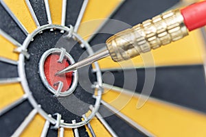 Dart arrow hitting in target bullseye of dartboard