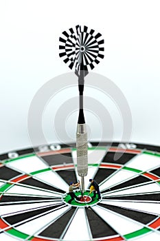 Dart arrow hitting in the target center of dartboard using as ba