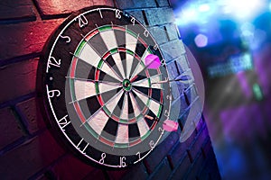 Dart board on a brick wall with dramatic lighting