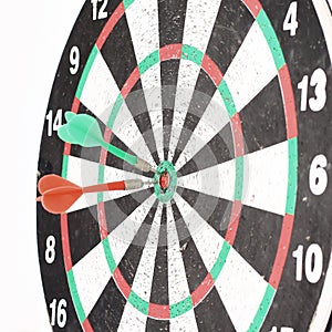 Dart Board with a dart in the center of the target