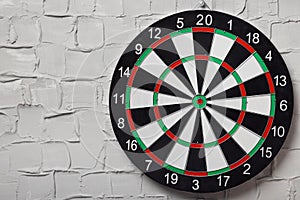 Dart board hanging on white textured wall