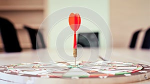 The dart board has an arrow thrown into the center of the shooting target for business targeting