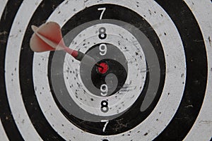 Dart board with red arrow hitting target