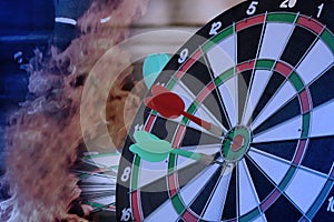 Dart hitting on center with fire on dartboard for business concept.