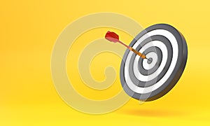 Dart hitting a target on the center on yellow background with copy space