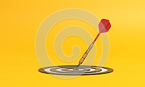 Dart hitting a target on the center on yellow background with copy space