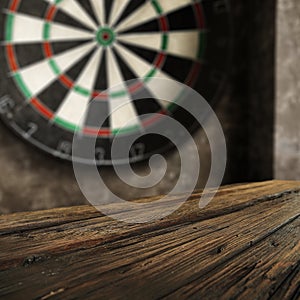 Dartboard with grey wall background. Wooden table with empty space. Darts playing time.