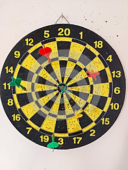 A dartboard hung on a beige wall