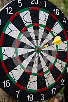 Darts in bull`s eye. Close up view of one yellow darts arrows in the target center