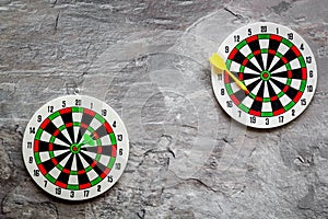 Darts game - simple sport for lesure time. Dartboard and arrows or dart on grey background top view copy space