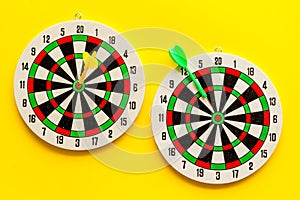 Darts game - simple sport for lesure time. Dartboard and arrows or dart on yellow background top view