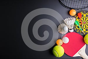 Darts, Racket table tennis, ping pong ball, Shuttlecocks, Badminton racket and Tennis ball on black background.Sport concept, Cop