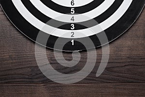 Darts target on dark wooden table