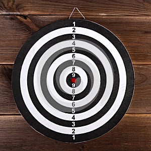 Darts target isolated on a wooden background. Hit the target
