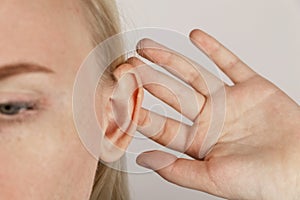 Darwin`s tubercle on the ear. The girl at the reception at the plastic surgeon, shows the auricle