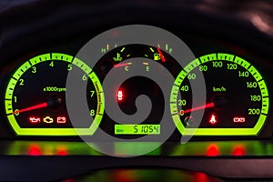 The dashboard of the car with green lights.