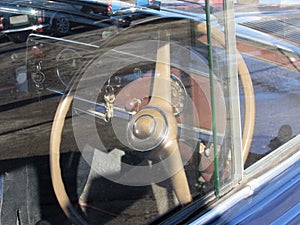Dashboard of a classic vintage car with modern car reflections