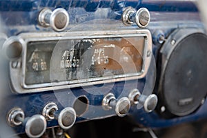 Dashboard at front of abandoned vintage truck with ammeter, oil indicator, various knobs