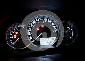 Dashboard instruments like odometer, speedometer, tachometer and control LEDs of modern car at night