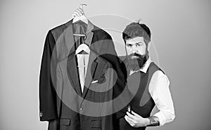 Dashing mens fashion and style. Fashion designer helping to choose suit jacket. Fashion stylist holding readymade coats