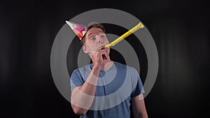 A dashing young man dons a colorful party hat, his bright smile and joyful demeanor capturing the spirit of celebration