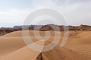 Dasht-e Kavir desert sand dunes with mountains on.